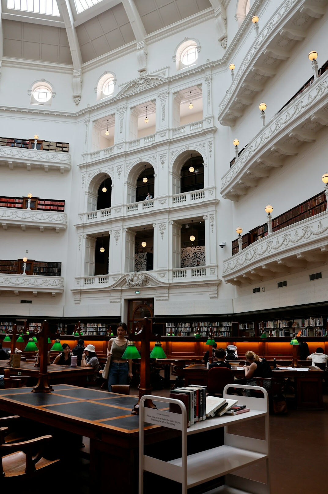 Person reading at a table inside a public library