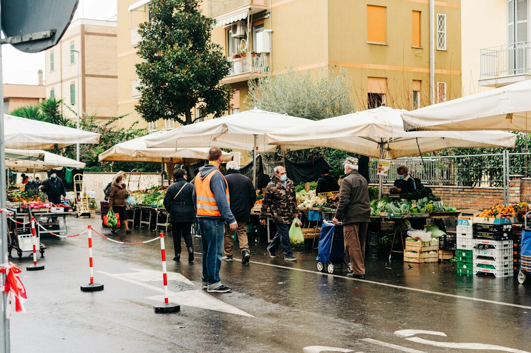 Diverse group of people browsing stalls at a neighbourhood market