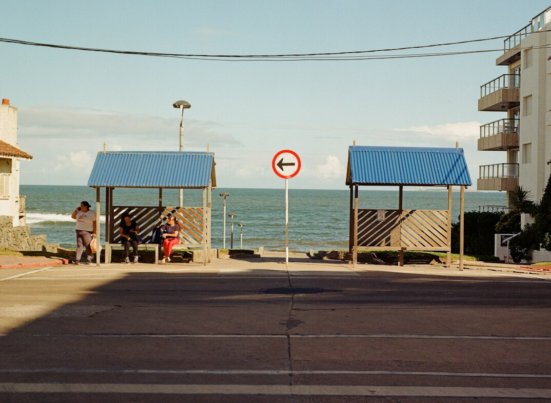 Person photographing a bus shelter on a quiet street